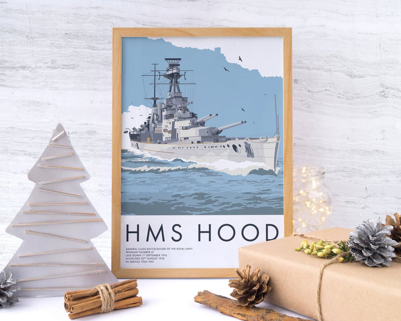 Framed HMS Hood print with a wrapped present, pine cones and fairy lights